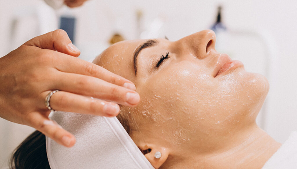 Cosmetologist cleaning face of a woman in a beauty salon