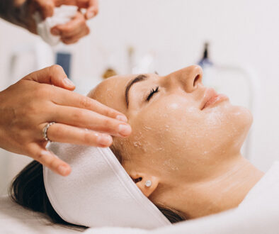 Cosmetologist cleaning face of a woman in a beauty salon